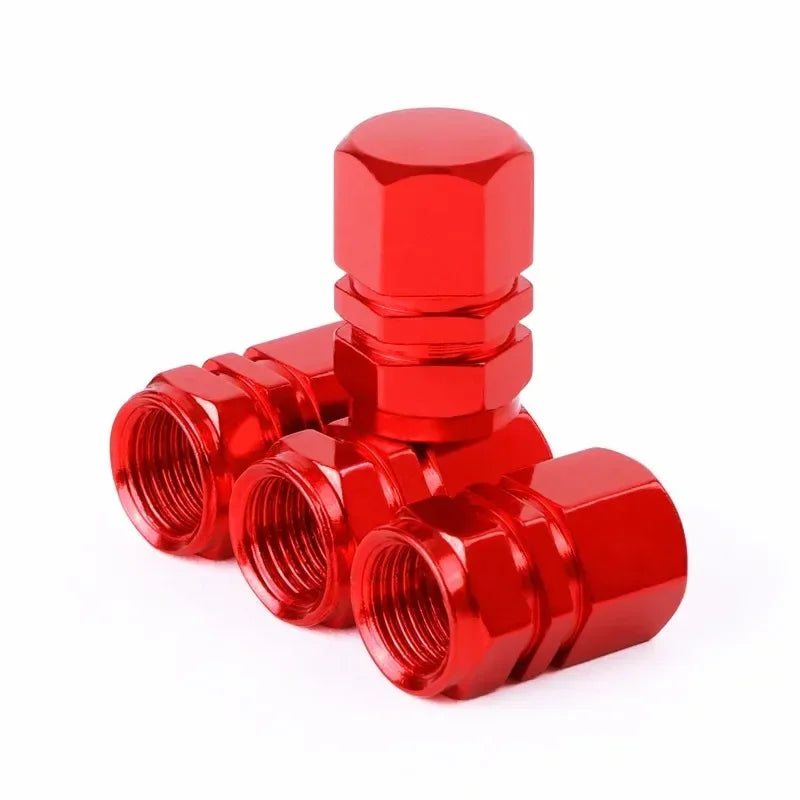 A set of four shiny red aluminum alloy wheel tire valve caps with a hexagon design.