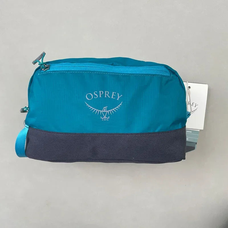 Sac de toilette pliable et imperméable Osprey bleu sarcelle avec un panneau gris foncé.