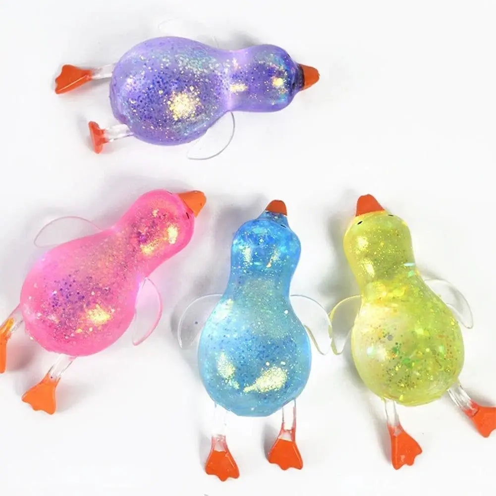 Drei glitzernde Enten-Kuscheltiere zum Stressabbau in lila, rosa und gelb.