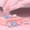 A set of six pink and white non-slip duvet cover clips are displayed on a pink surface with a pink fabric draped in the backg