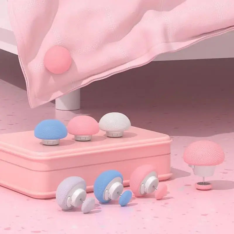 A set of six pink and white non-slip duvet cover clips are displayed on a pink surface with a pink fabric draped in the backg