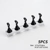Five black reusable nail glue clay pieces displayed on a clear glass shelf.
