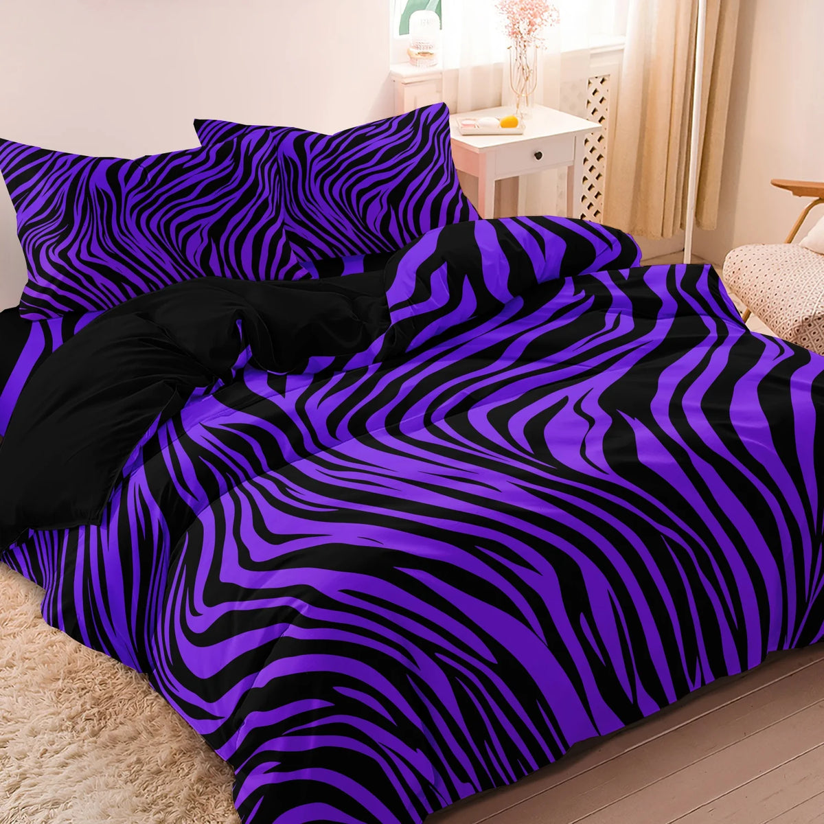 A purple and black zebra print duvet cover set displayed on a bed.
