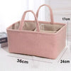 A pink fabric diaper bag organizer with handles and bottle storage is shown on a white surface.