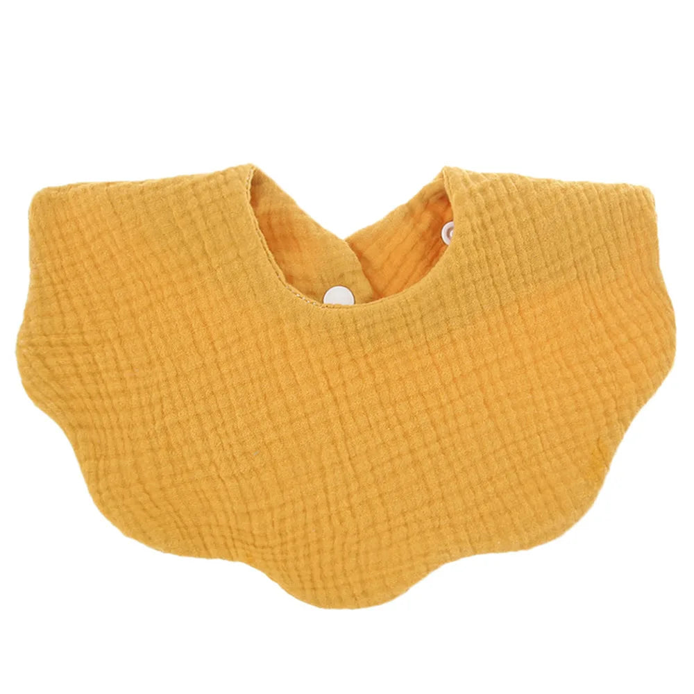 A mustard yellow soft cotton baby bib in a bandana style with a rounded neckline.