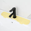 Yellow silicone sink faucet mat with a black rotating splash guard installed on a white sink.