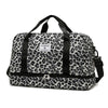 Schwarze und weiße Leopardenmuster-Gepäcktasche mit schwarzen Riemen und Reißverschlüssen.