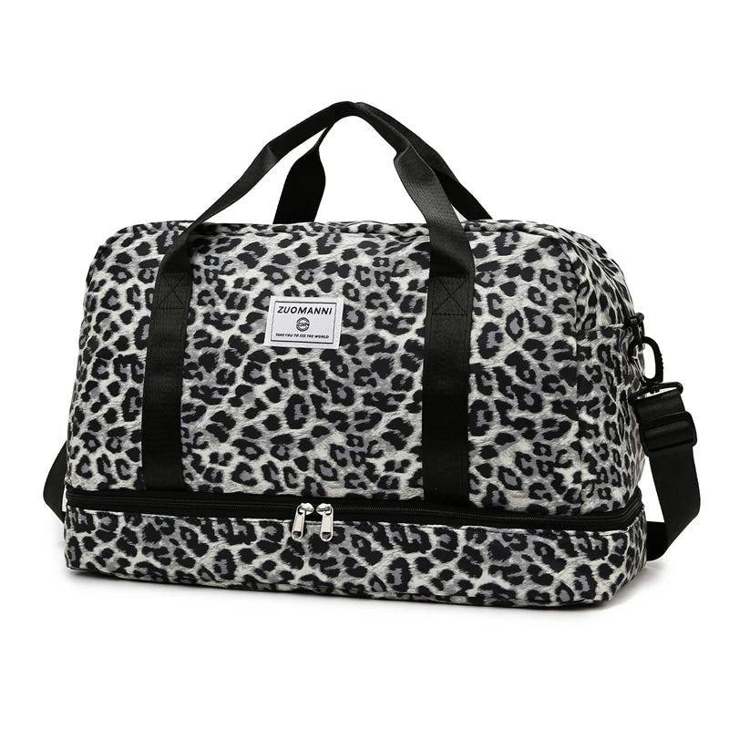 Schwarze und weiße Leopardenmuster-Gepäcktasche mit schwarzen Riemen und Reißverschlüssen.
