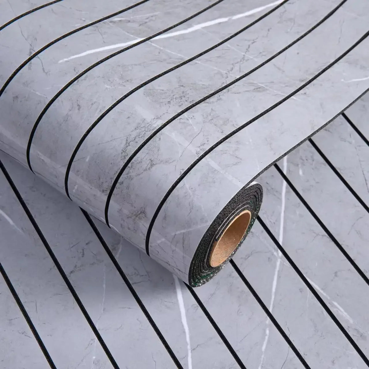 Roll of gray marble peel-and-stick wallpaper featuring thin black stripes and subtle veining.
