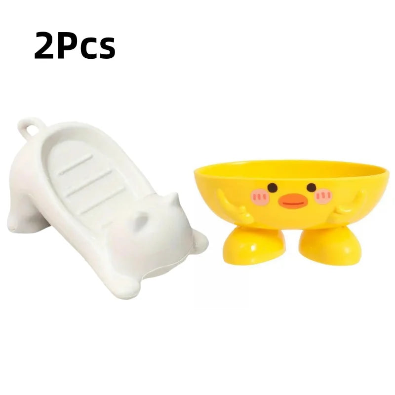 Two yellow cat-shaped soap dishes with drainage trays