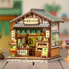 A detailed miniature Japanese book nook kit featuring a traditional wooden building with an open shop and lighting.