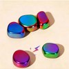 Ein Satz magnetischer Schachfiguren in verschiedenen irisierenden Farben auf hellem Hintergrund.