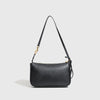 A black classic leather tote bag with a long strap and a gold-toned metal buckle.
