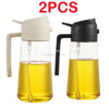Two glass oil spray bottles with black and white tops for cooking