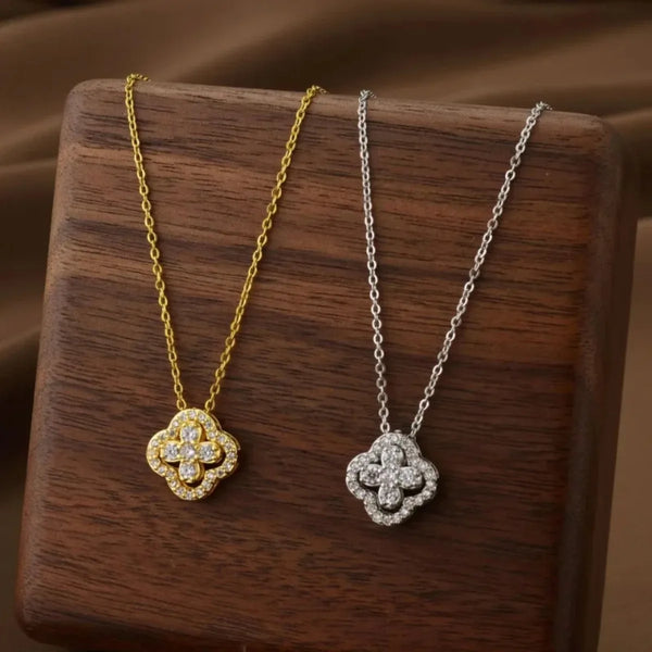 Un collier de fleurs délicat en or et argent, exposé sur une surface en bois sombre.