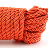 Coiled orange soft silk bondage rope used for couples roleplay