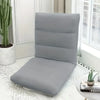 A gray foldable floor sofa cover for a single seat or lounger placed on a white textured rug.
