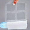 A hand is placing a mesh filter into a white plastic shower drain hair catcher.