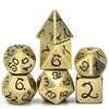 A set of seven metal polyhedral dice in gold color featuring a dragon font design.