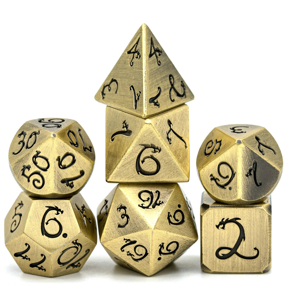 A set of seven metal polyhedral dice in gold color featuring a dragon font design.