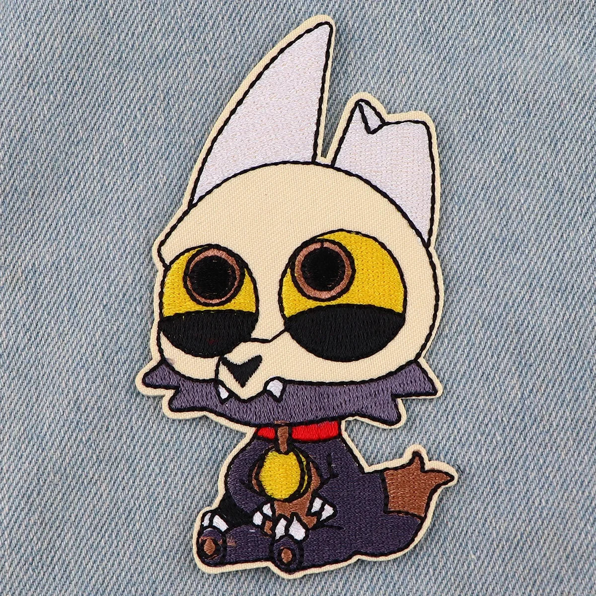 An embroidered patch of a stylized white cat dragon head with large yellow eyes and dark markings.