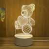 A glowing wireframe bear sculpture displayed on a round base, illuminated by a USB light.