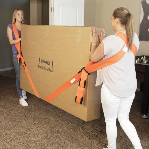 A woman is using orange furniture moving straps to secure a large cardboard box for moving.