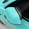 A close-up of a teal Subaru rain guard mirror visor with black lettering that reads LEGACY.