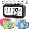 A collection of compact LED digital alarm clocks in pink, lime green, white, and blue.