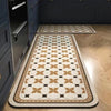 A long rectangular kitchen rug with a classic beige and brown geometric pattern is displayed on a wooden floor.