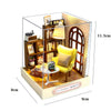 A miniature wooden dollhouse display featuring a yellow armchair and shelving with LED lighting.