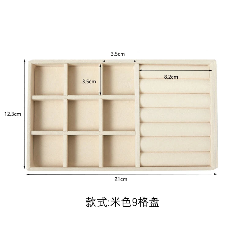 A beige velvet jewelry organizer tray with nine detachable compartments.