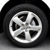 Silver Audi wheel with tire mounted on a black vehicle.