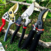 A collection of precision pruning shears with SK-5 steel blades resting on green grass and a wooden branch.