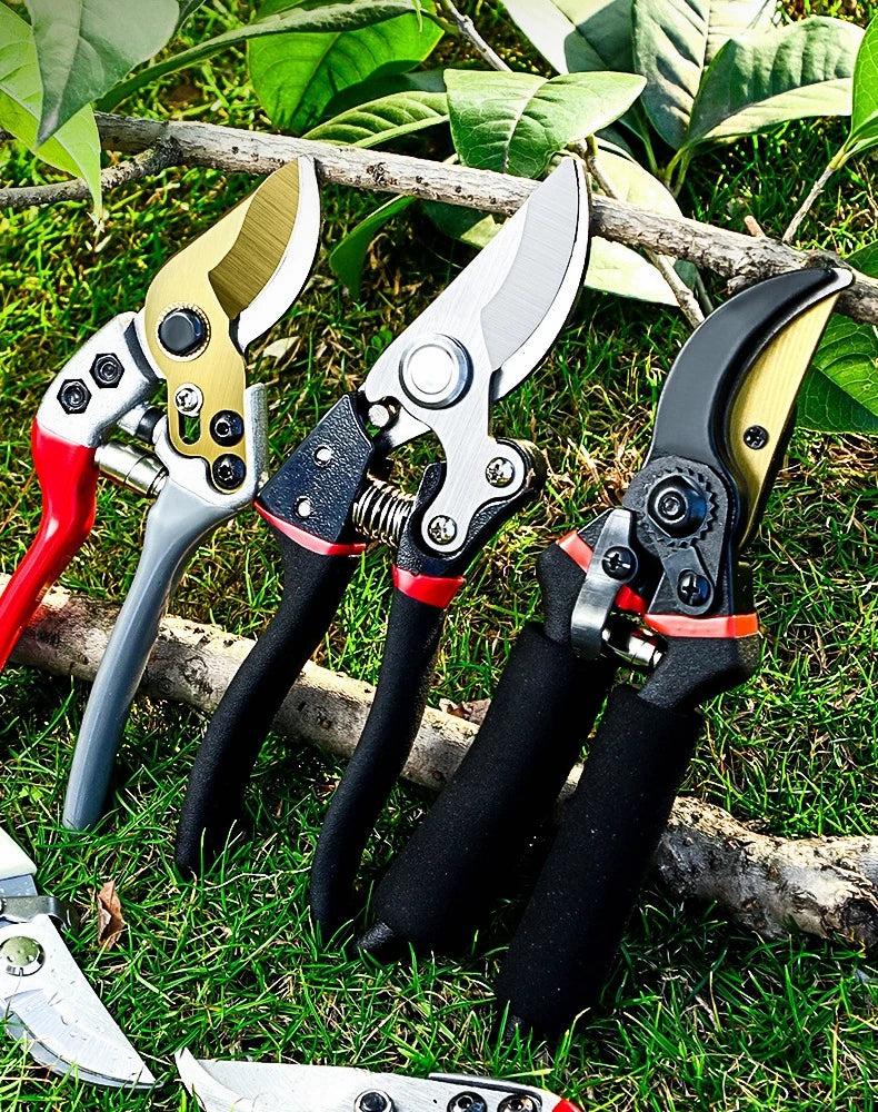 A collection of precision pruning shears with SK-5 steel blades resting on green grass and a wooden branch.