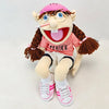A plush toy of the character Feebee with brown hair, pink shirt, and glasses.
