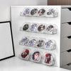 A white wall-mounted display shelf holding multiple clear acrylic plastic cases filled with various colored and textured art 