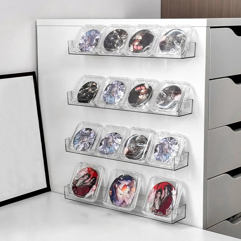 A white wall-mounted display shelf holding multiple clear acrylic plastic cases filled with various colored and textured art 