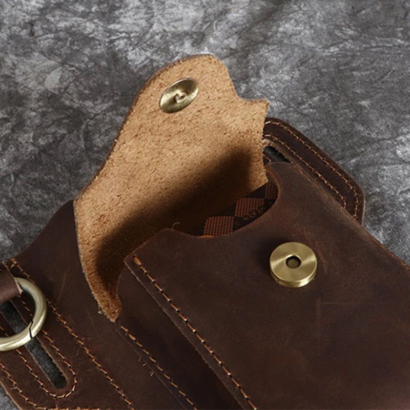 A close-up of a brown genuine leather waist bag with stitching and a brass button.