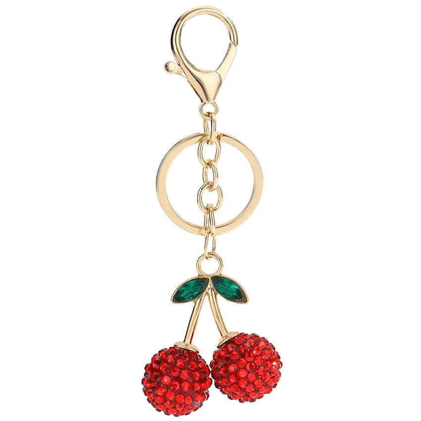 Gold crystal cherry keychain with a lobster clasp and green leaves