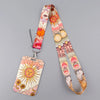 A pink and orange patterned lanyard with a sun design attached to an ID badge holder.