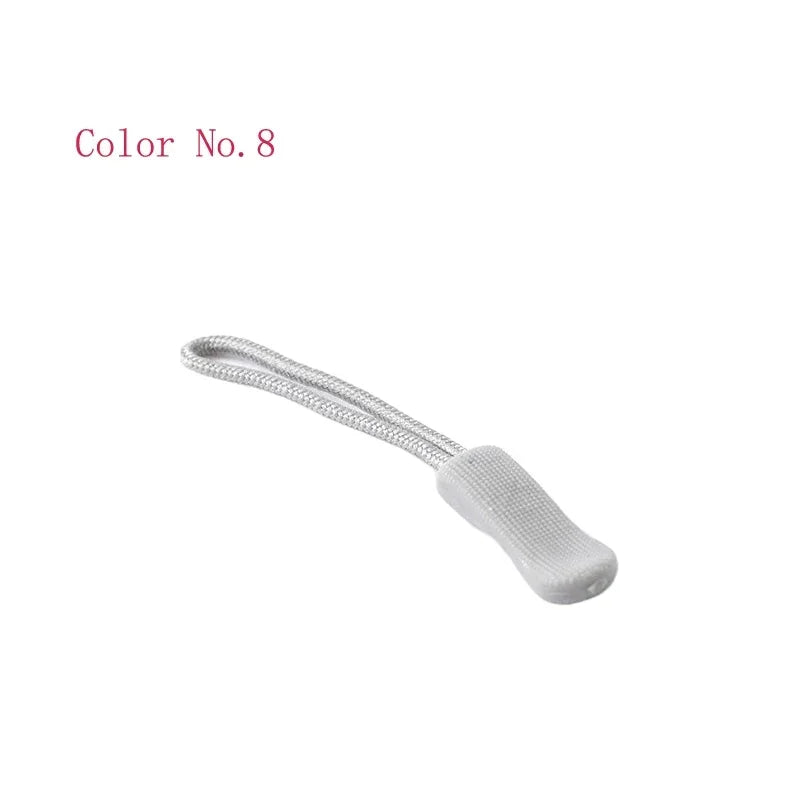 A close-up view of a silver plastic zipper pull with a white fabric loop attached.
