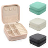 A set of PU leather jewelry storage boxes in pink, beige, and gray, some zipped for travel.