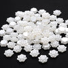 A pile of 100 white acrylic pearl spacer beads for jewelry making.