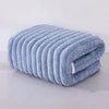 A rolled light blue microfiber towel with ribbed texture is shown on a white surface.