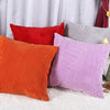 A set of striped velvet corduroy cushion covers in shades of orange, red, purple, and gray.