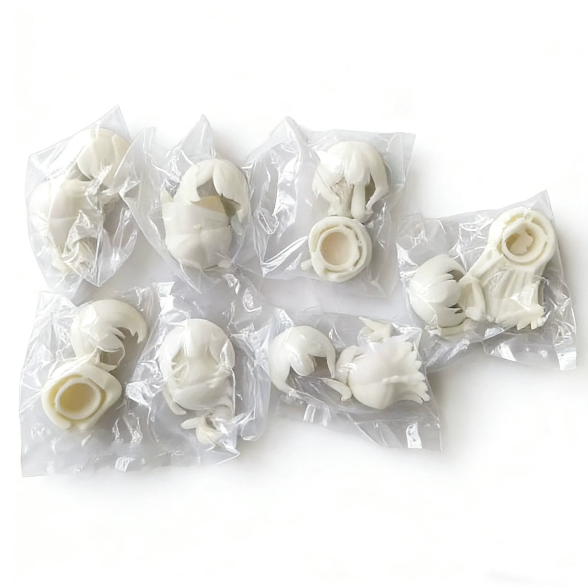 A collection of white articulated BJD collectible figurines packaged in clear plastic bags.