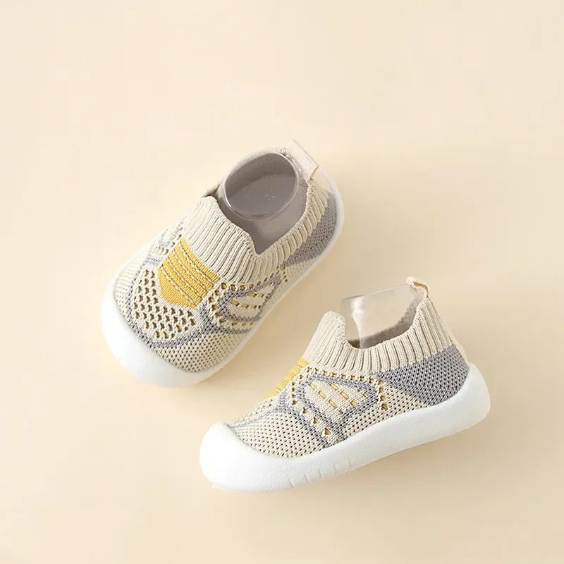 A pair of beige and gray breathable soft-sole baby shoes with non-slip grip shown from above.