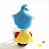 A blue plush toy resembling a clown with a yellow cape sitting on a white surface.
