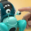 A hand is shaking a soft silicone eye on a teal crawling crab toy for fun.